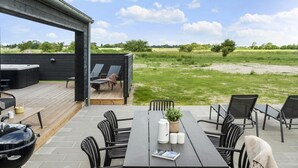 An outdoor patio with a table, chairs, a grill, and lounge chairs. - VillaVilla 923 - Marielyst, Lolland/Falster/møn (Idestrup)