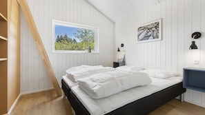 A bedroom with a bed, a window with a view of trees, a bedside table with a lamp, and a wall-mounted picture. - VillaVilla 931 - Ebeltoft, Østjylland (Ebeltoft)