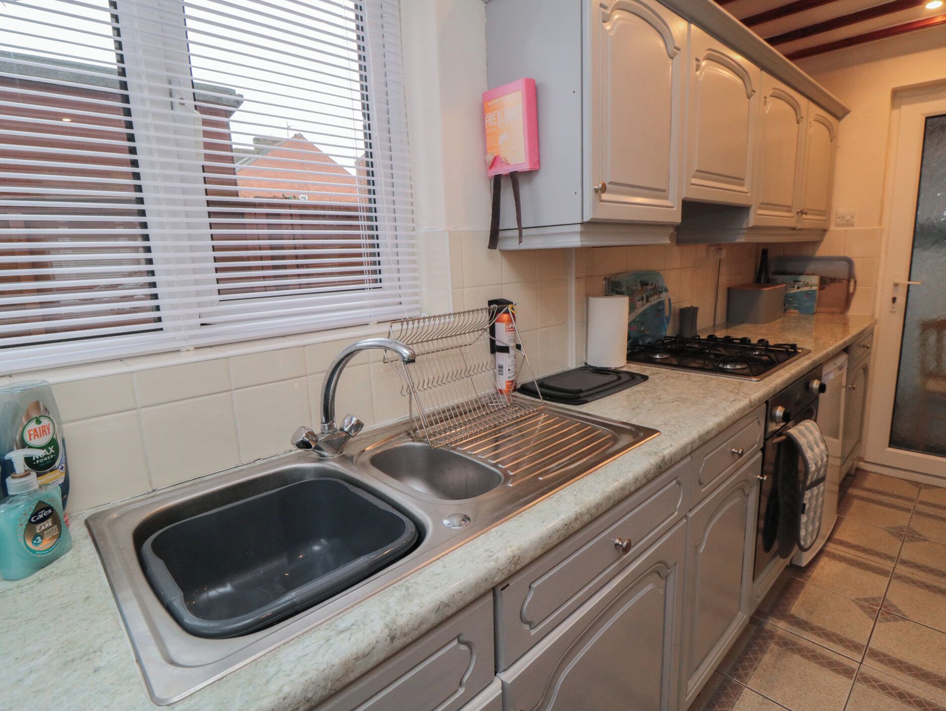 A kitchen with a double sink, a stove, and a dishwasher.