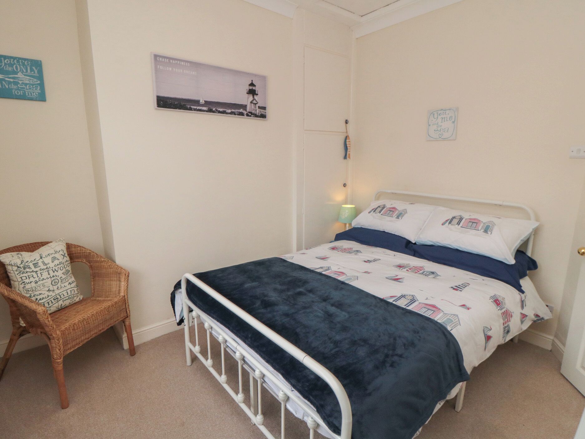 Un dormitorio con una cama, una silla y un cartel en la pared.