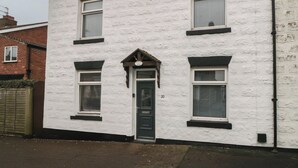 A two-story white building with a black door and windows. - Seabreeze (Filey)