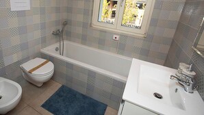 Ein Badezimmer mit Badewanne, Toilette und Waschbecken.