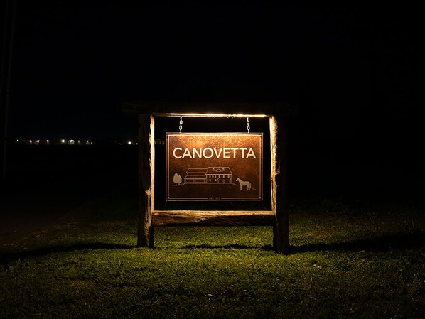 A signboard with the name "CANOVETTA" and a logo, mounted on a wooden frame. - Canovetta Country Houses (Persico Dosimo)