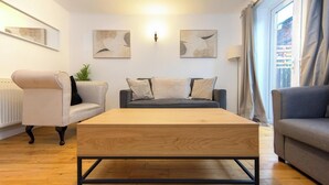 A modern living room with a wooden coffee table, two sofas, and a radiator. - Stylish Town House - Located close to Derby centre (Derby)