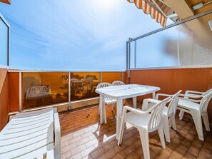 Una terrazza sul tetto con tavolo e sedie, vista su un ponte e cielo sereno.