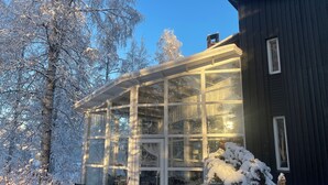 Ein Haus mit einer großen Glaskuppel, umgeben von schneebedeckten Bäumen.