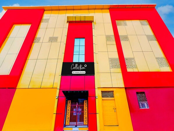 A building with a vibrant facade, featuring a prominent 'Collection' sign, large windows, and a central entrance with a decorative door. - Collection O Nehru Nagar (Ghaziabad)