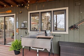 A kitchen area with a sink, a window, and fishing rods.