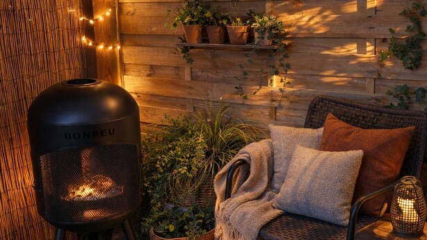 A cozy outdoor seating area with a wicker chair, a round rug, and a small table with a lantern. - La Villa Bellerose is a cosy Zen gîte on the Côte d'Opale, near Le Touquet. (Beutin)