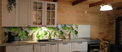 A kitchen with white cabinets, a coffee machine, and a stove.