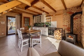 Ein gemütliches Blockhaus-Interieur mit Essbereich, Küche und Kaminofen.