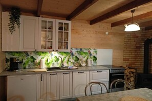 A kitchen with white cabinets, a coffee machine, and a stove.