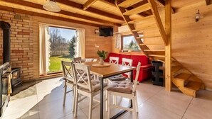 Un interno in legno con un tavolo da pranzo, sedie, un divano rosso e una scala.