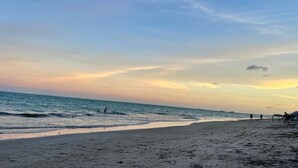 Une plage avec un ciel dégagé et une mer calme.