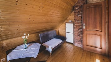 Un interior de madera con un sofá, una mesita con un florero y un armario.