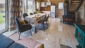 A cozy cabin interior with a dining area, kitchen, and a fireplace. - Large holiday home, salt cave, jacuzzi, sauna (Balachy)