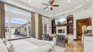 Ampia camera da letto con un grande letto, una ventola a soffitto e vista sull'esterno.