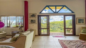En rummelig stue med en stor skydedør, der giver udsigt til et smukt udendørs landskab.