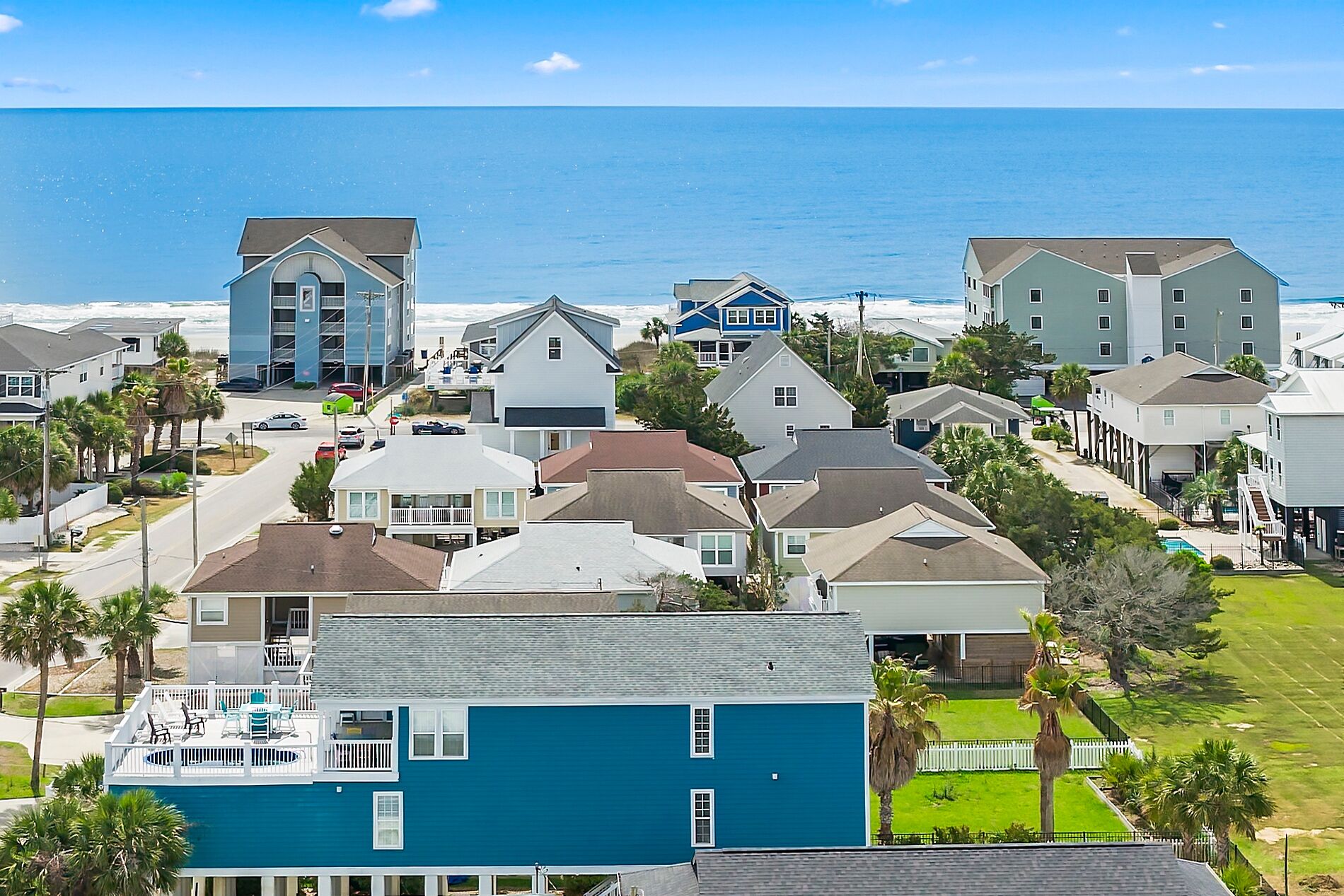 Un quartier résidentiel situé sur la côte, avec des maisons, une piscine et une vue sur l’océan.