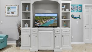 A living room with a flat-screen TV, white cabinetry, a framed picture, and decorative items. - Murrells Inlet - 163 It's Five O'Clock Somewhere (Murrells Inlet)