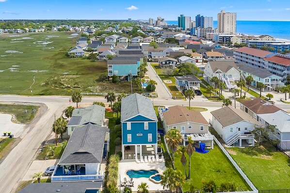 Un quartier résidentiel avec des maisons, une piscine et une vue sur l’océan.
