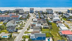An aerial view of a coastal residential area with houses, a road, and a beach. - Murrells Inlet - 163 It's Five O'Clock Somewhere (Murrells Inlet)
