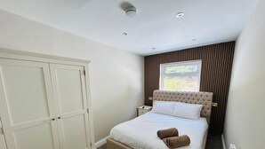 Une chambre à coucher avec un lit, une armoire, une fenêtre et un radiateur.