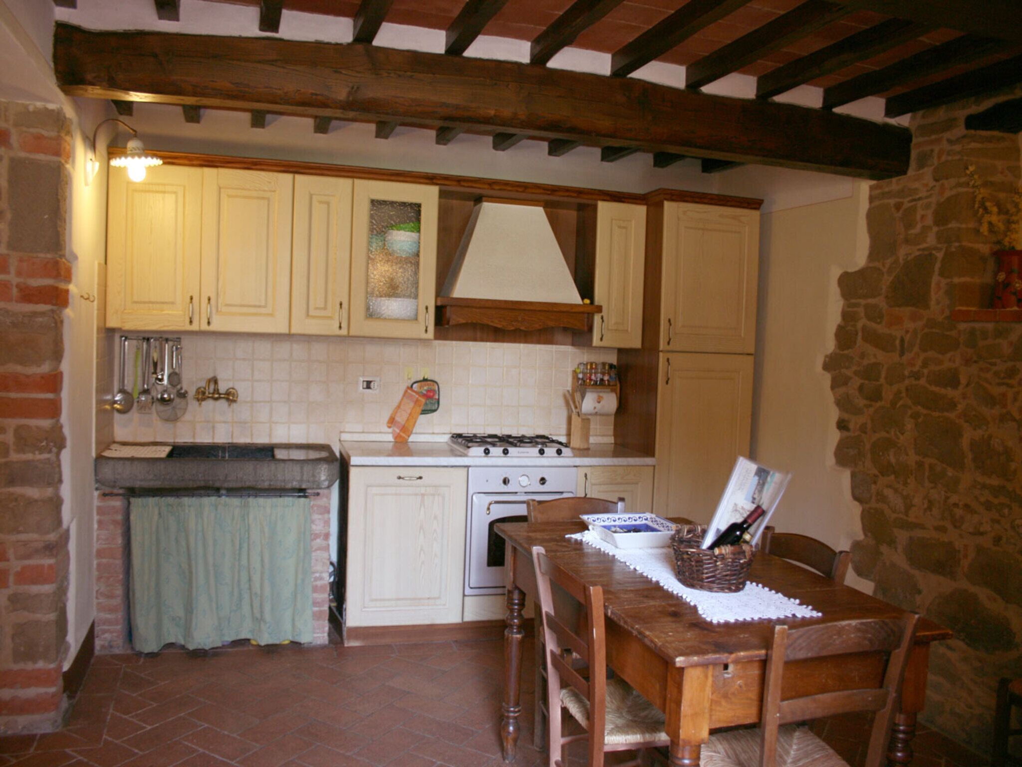 Una cucina con un fornello, mobili e un tavolo da pranzo con sedie.