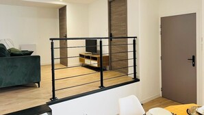 A modern living room with a staircase, a sofa, a coffee table, and a television. - CITY LOFT VALENCE HYPER CENTER (Valence)