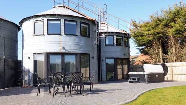 A modern, cylindrical building with a flat roof and large windows. - The Barley Silo (Ipswich)