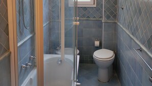 A modern bathroom with a glass-enclosed shower, a bathtub, and a toilet. - The Florence Nest (Firenze)