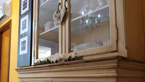 Un mobile contenitore in legno dallo stile vintage, con vetrine, un piano decorativo e diversi cassetti.
