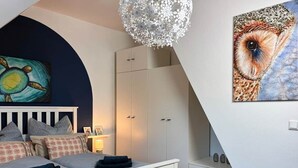 Une chambre à coucher avec un lit, une armoire, un bureau et un tableau.