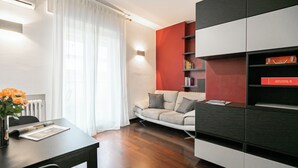 Moderni olohuone, jossa on sohva, sohvapöytä ja kirjahylly.