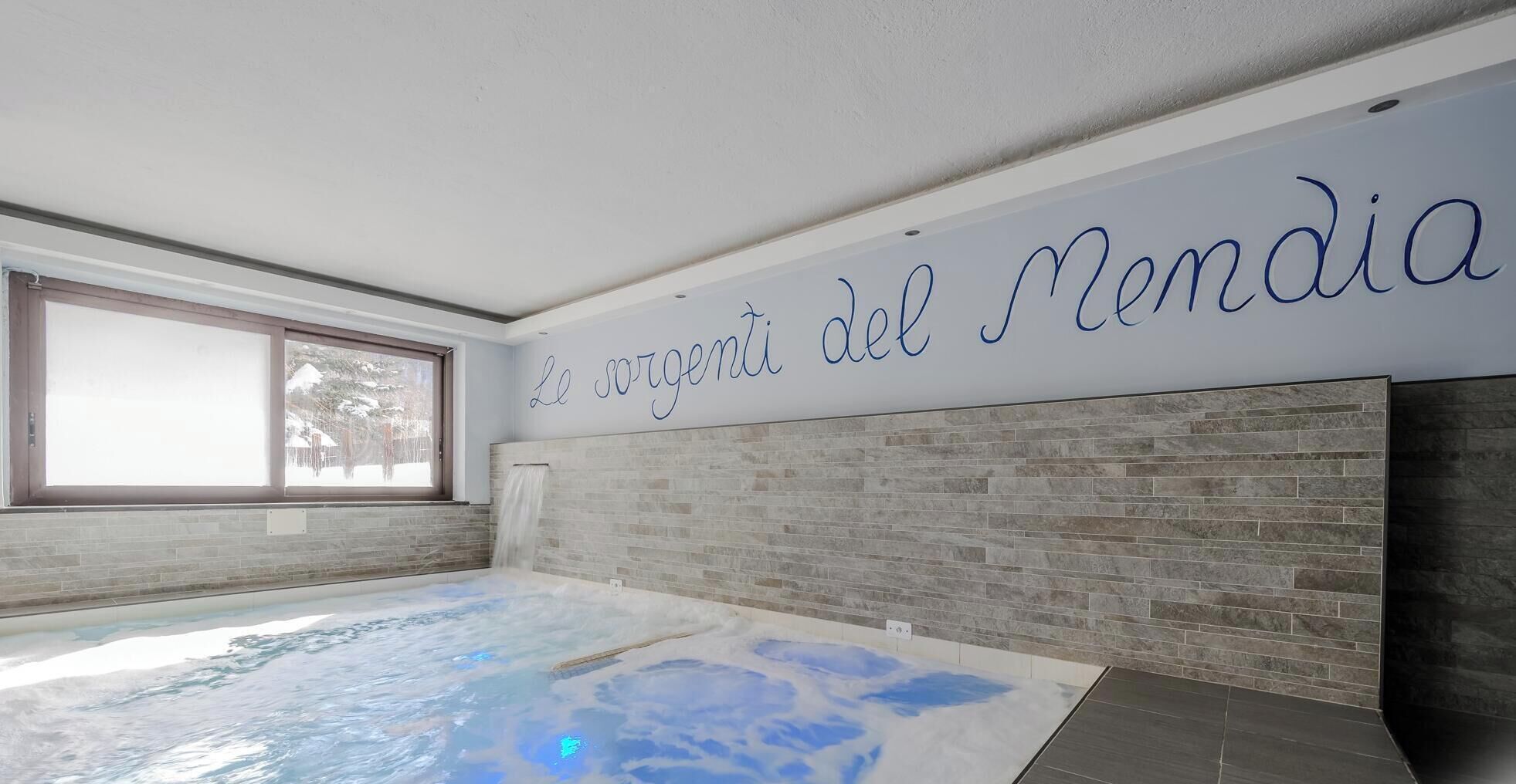 Una piscina interior moderna con vistas despejadas al exterior a través de un amplio ventanal.