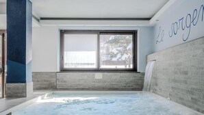 A modern bathroom with a large window, a bathtub, and a shower area. - Hotiday Pragelato (Pragelato)
