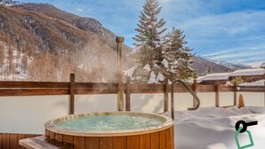 A wooden hot tub with a view of snow-covered mountains and a clear sky. - Hotiday Pragelato (Pragelato)