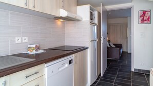 A modern kitchen with light wood cabinets, a built-in dishwasher, and a stainless steel refrigerator. - Sud Ocean M Ndeg105 - 2P5 (Guidel)