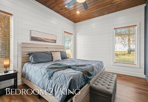A bedroom with a large bed, wooden headboard, and a bench. - Pet-Friendly Forest Retreat for Couples, Friends (Broken Bow)