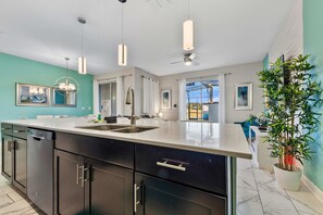 A modern kitchen with a large island, stainless steel appliances, and pendant lighting. - Epic Level-Up Villa - Walk to Oasis Club - Mario Room  Mural Pool (Davenport)