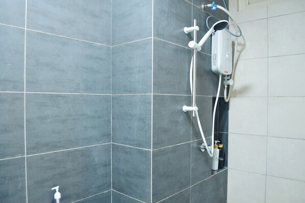 A shower with a handheld showerhead and a wall-mounted faucet, set against a tiled wall. - KLIA Airport Homestay 18 Horizon Suites (Sepang)