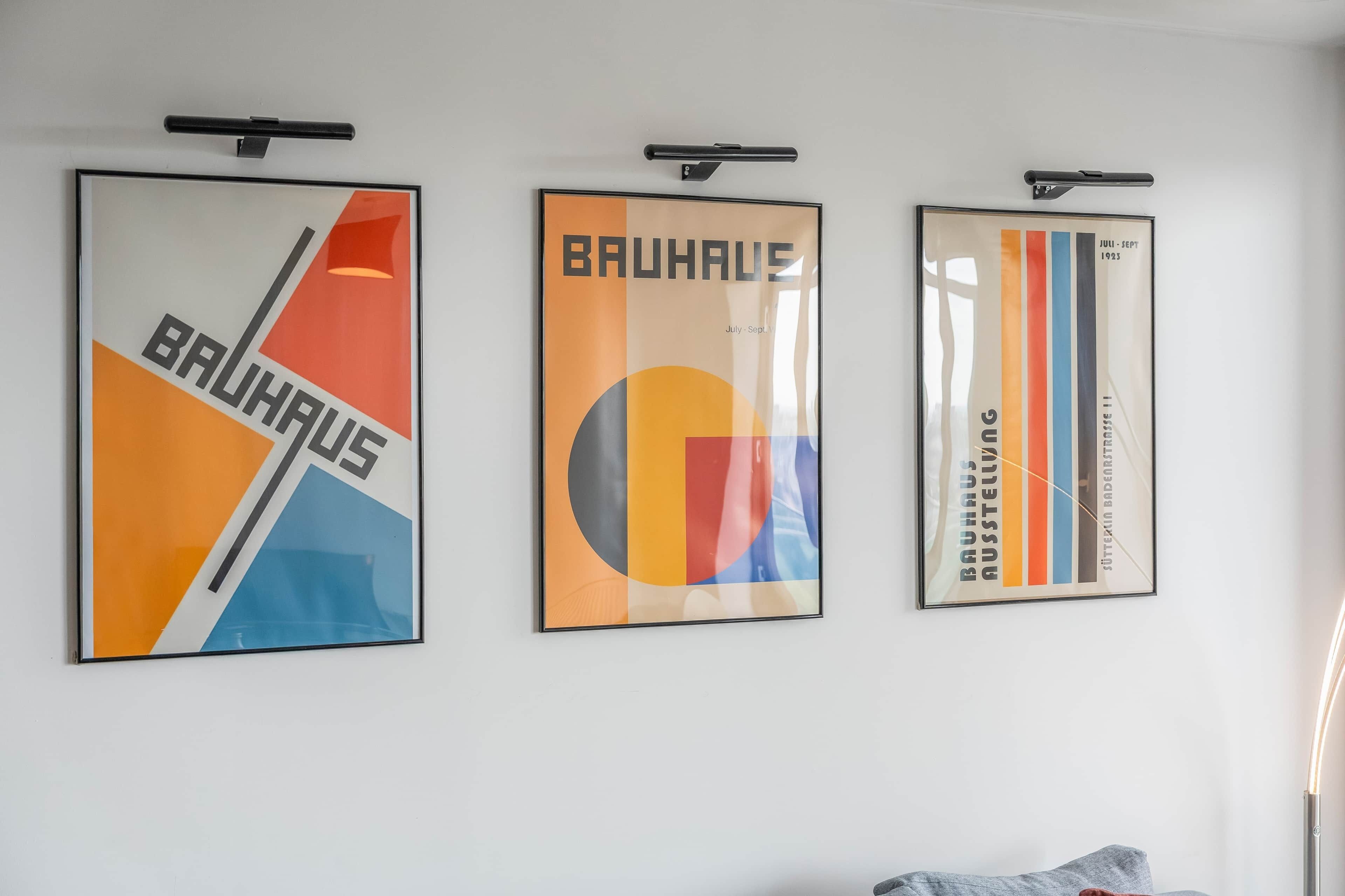 Tre Bauhaus-affischer på en vit vägg.