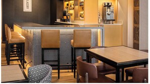 Uma área de bar com balcão, assentos e uma televisão.