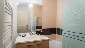 A bathroom with a white sink, wooden cabinet, and a mirror. - Apartment Near Plage Moutchic Lake (Lacanau)