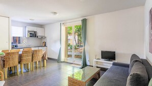 A compact living space with a kitchenette, dining area, and a seating area with a TV. - Apartment Near Plage Moutchic Lake (Lacanau)