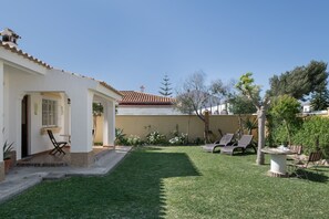A house with a patio, a covered area, and a well-maintained lawn. - Rural House 'Casas Pepe 1' with Private Terrace, Wi-Fi and Air Conditioning (Los Caños de Meca)