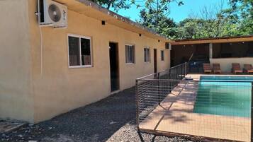 Un bâtiment doté d’une piscine, d’un espace clôturé et d’un appareil de climatisation.