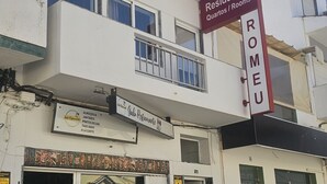 Un edificio con un cartello che indica 'Residencial Quartos / Rooms' e un ristorante chiamato 'Gabo Restaurante'.