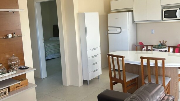 Un espacio habitable compacto con kitchenette, comedor y sofá.
