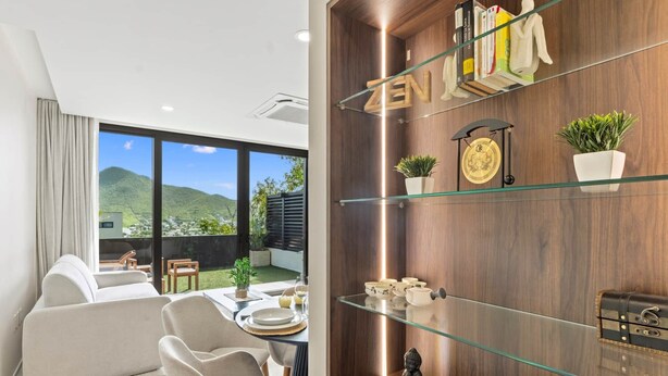 A modern living room with a glass table, chairs, and a view of a mountain. - D401 Beautiful apartment with a garden lagoon view (Cole Bay)